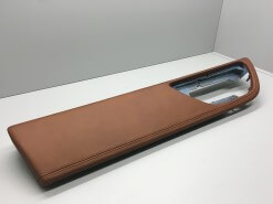 A leather trimmed automotive door panel sits on the shelf automotive manufacturing services        